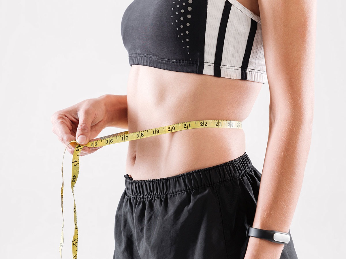 Image of a woman measuring her stomach